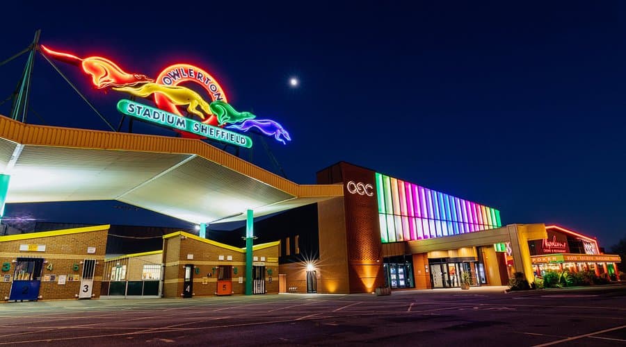 Owlerton Stadium at night, its neon greyhound sign lit above the entrance